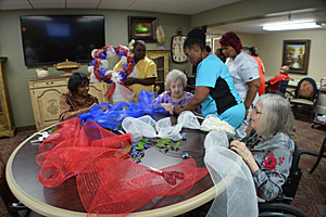 group of people decorating a wreath